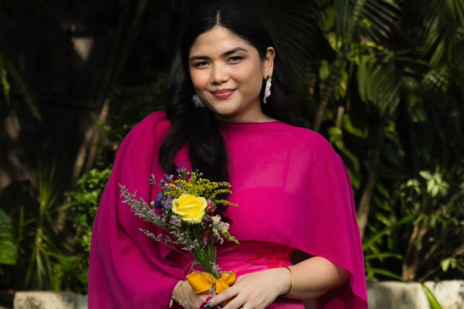 Nadz wearing a hot pink outfit holding flowers